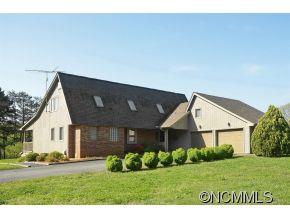 1400 South Wilson Hill Road Mill Spring, NC 28756 - Photo 1 of 24 a front view of a house with a yard and garage
