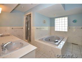 1400 South Wilson Hill Road Mill Spring, NC 28756 - Photo 11 of 24 a bathroom with a tub sink and mirror