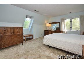 1400 South Wilson Hill Road Mill Spring, NC 28756 - Photo 12 of 24 a bed sitting in a spacious bedroom next to a window