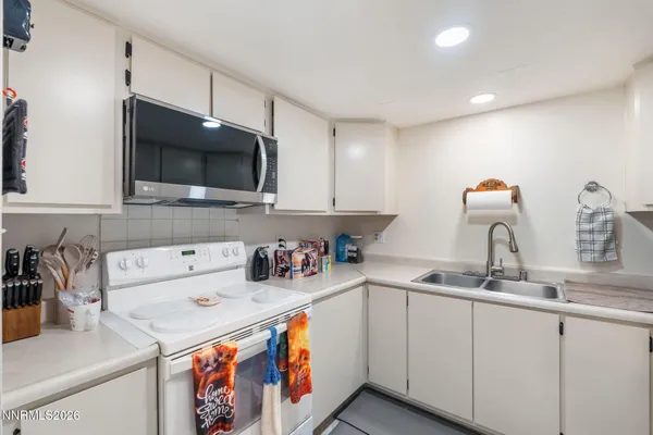 a kitchen with a sink a microwave and cabinets