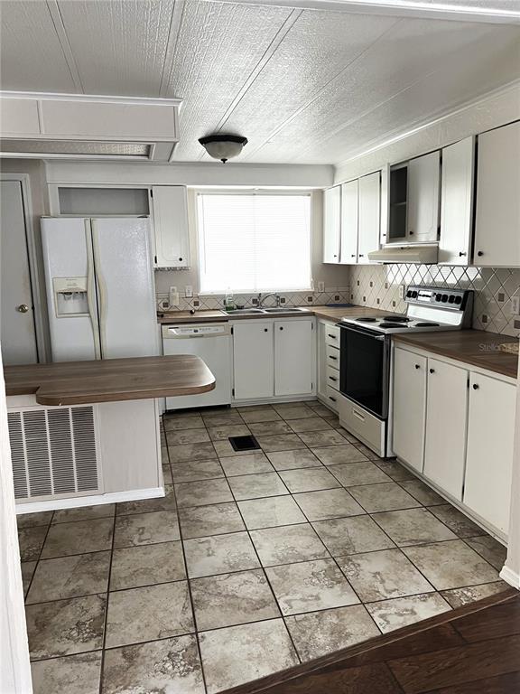 5020 Sydney Road Plant City, FL 33566 - Photo 28 of 33 a large kitchen with granite countertop a stove a sink a window and white cabinets