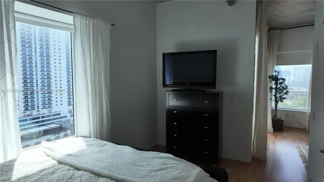 a bedroom with a bed and a television