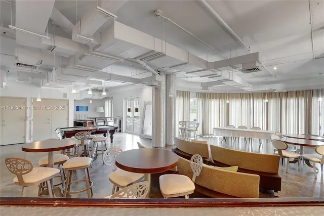 a living room with furniture kitchen view and a large window