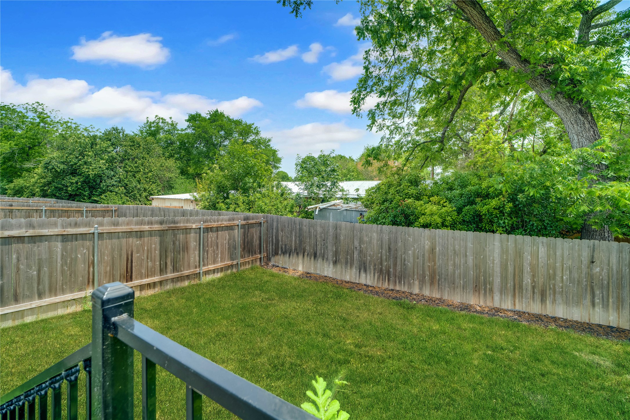 36 Trinity Circle Lockhart, TX 78644 - Photo 32 of 36 a view of a backyard with a small cabin and wooden fence
