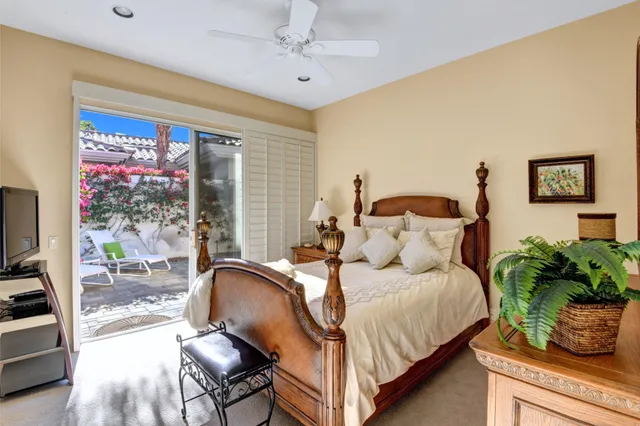 a bedroom with a bed potted plant on the dresser and a large window