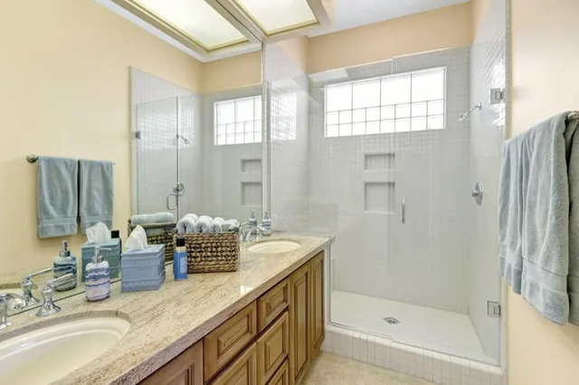 a bathroom with double vanity sinks and a shower