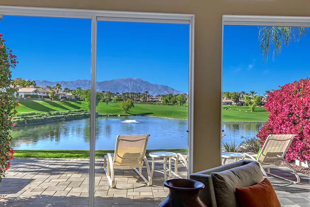 a view of a chairs and table in patio with a lake view