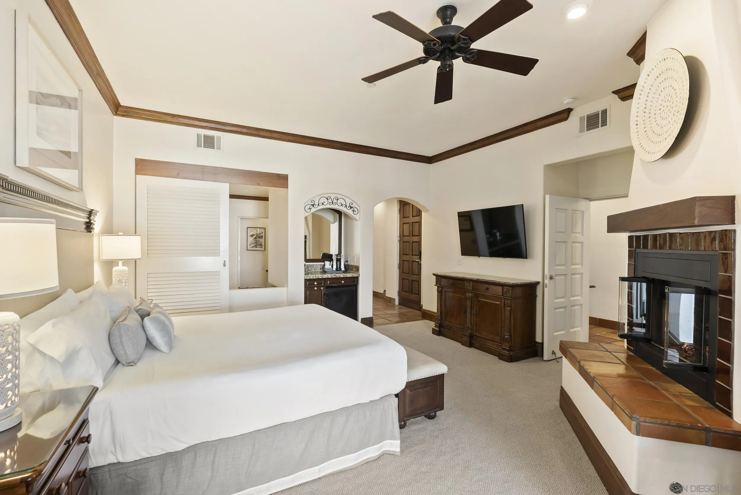 7310 Estrella De Mar Road, Unit 3 Carlsbad, CA 92009 - Photo 18 of 32 a spacious bedroom with a bed a flat screen tv and a fireplace