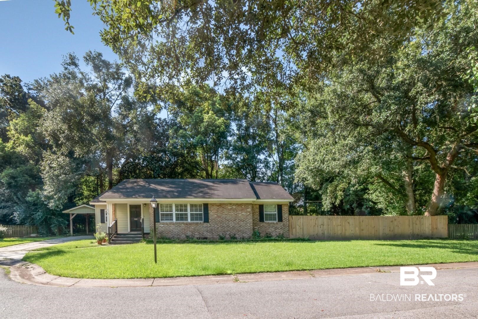 2105 Upham Court Mobile, AL 36607 - Photo 5 of 32 Single story home featuring brick siding, a porch, crawl space, and view of wooded area
