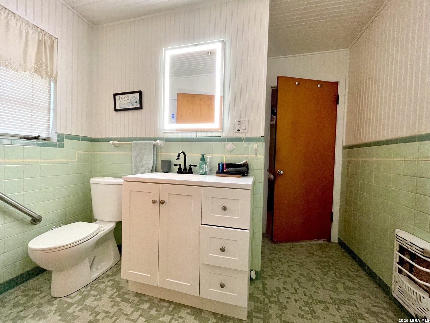 803 Cherry Street Uvalde, TX 78801 - Photo 16 of 17 a bathroom with a toilet a sink a mirror and a shower