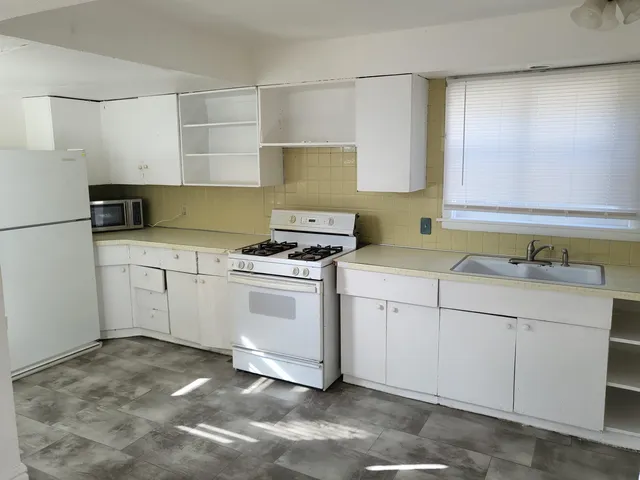 a kitchen with white cabinets sink and white appliances