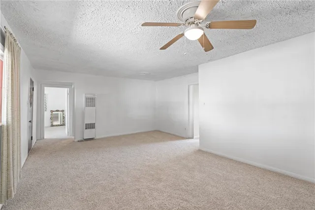 an empty room with chandelier fan