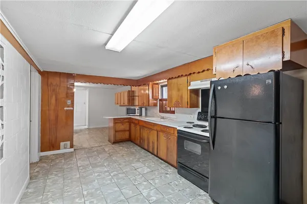 a kitchen with stainless steel appliances granite countertop a refrigerator a sink and a stove