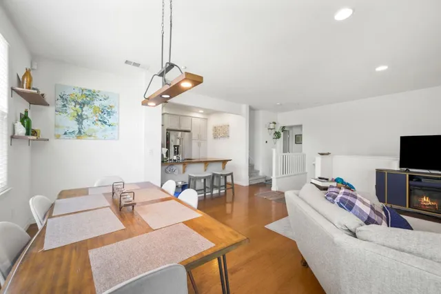 a living room with furniture a flat screen tv and a dining table