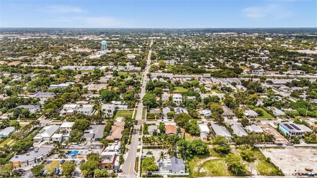 a view of house with yard outdoor seating and trees in the background