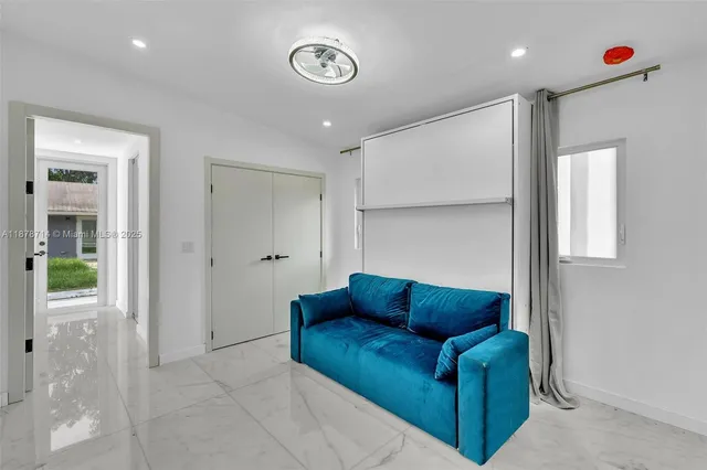 a large white kitchen with a large window and stainless steel appliances