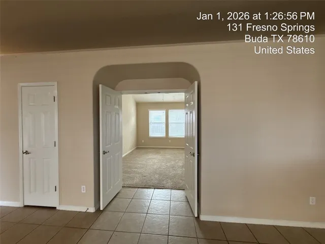 an empty room with windows and ceiling fan