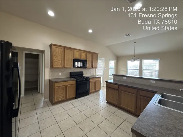 a large kitchen with stainless steel appliances granite countertop a sink and a refrigerator
