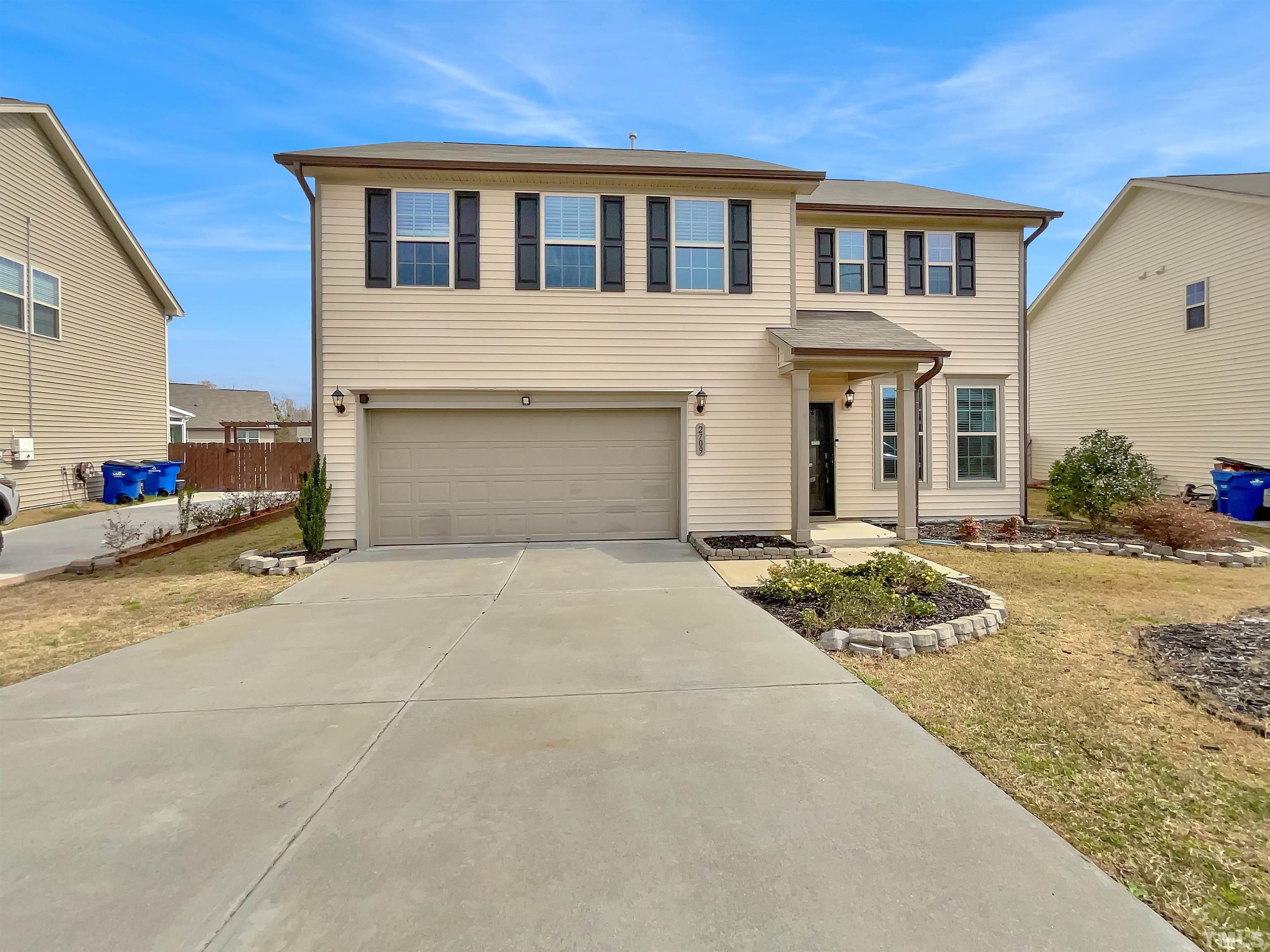 2709 Communion Court Raleigh, NC 27610 - Photo 1 of 18 a front view of a house with a yard and garage
