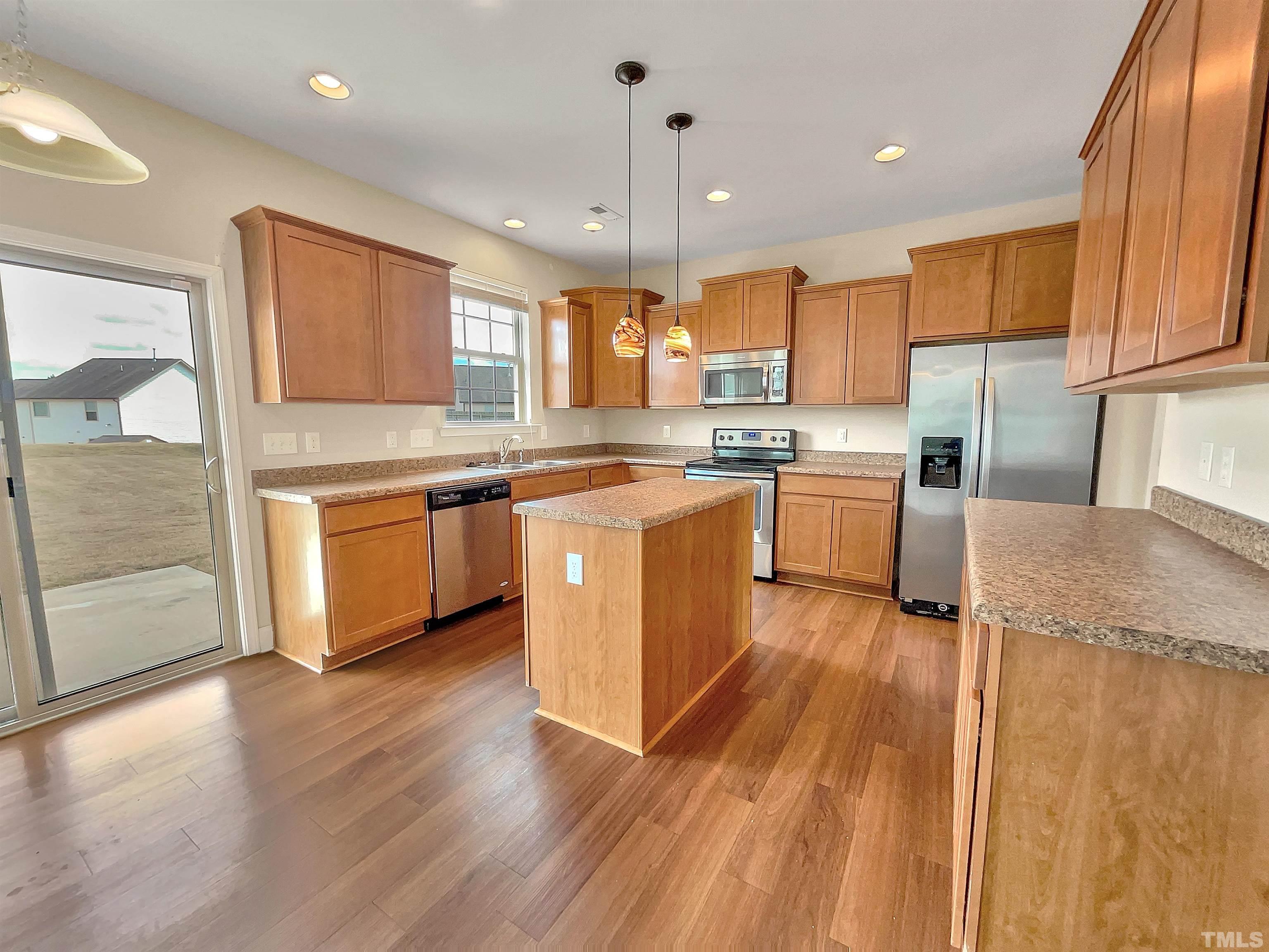 2709 Communion Court Raleigh, NC 27610 - Photo 9 of 18 a kitchen with stainless steel appliances granite countertop wooden cabinets and a granite counter tops