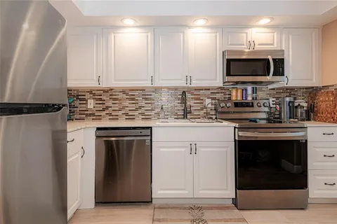 a kitchen with stainless steel appliances granite countertop a stove top oven microwave and cabinets