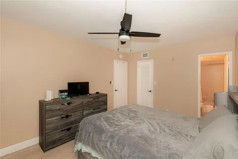 a bedroom with a bed and a flat tv screen on a dresser