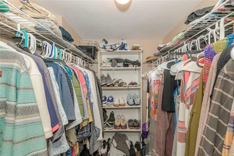 a view of walk in closet with clothes and shoes