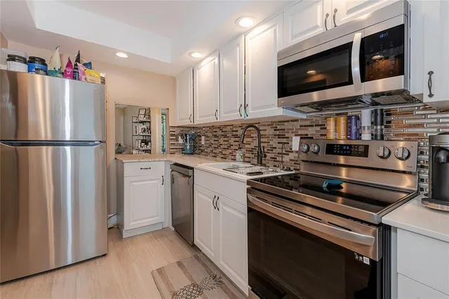 a kitchen with stainless steel appliances a refrigerator stove and microwave