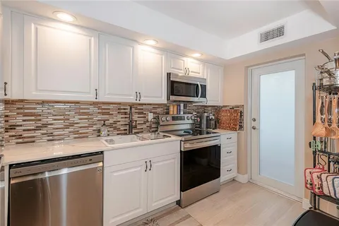 a kitchen with stainless steel appliances granite countertop a stove sink and refrigerator