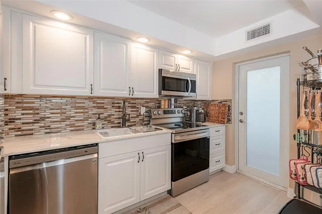 a kitchen with stainless steel appliances granite countertop a stove sink and refrigerator