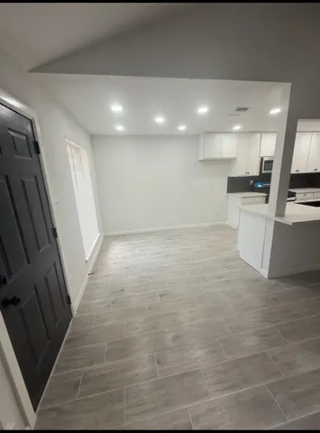 a view of a kitchen with kitchen island a sink wooden floor and a counter top space