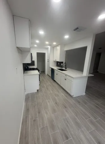 a view of a house with a yard and large tree