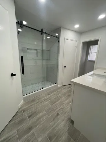 a large kitchen with stainless steel appliances granite countertop a stove a sink dishwasher and a refrigerator with wooden floor