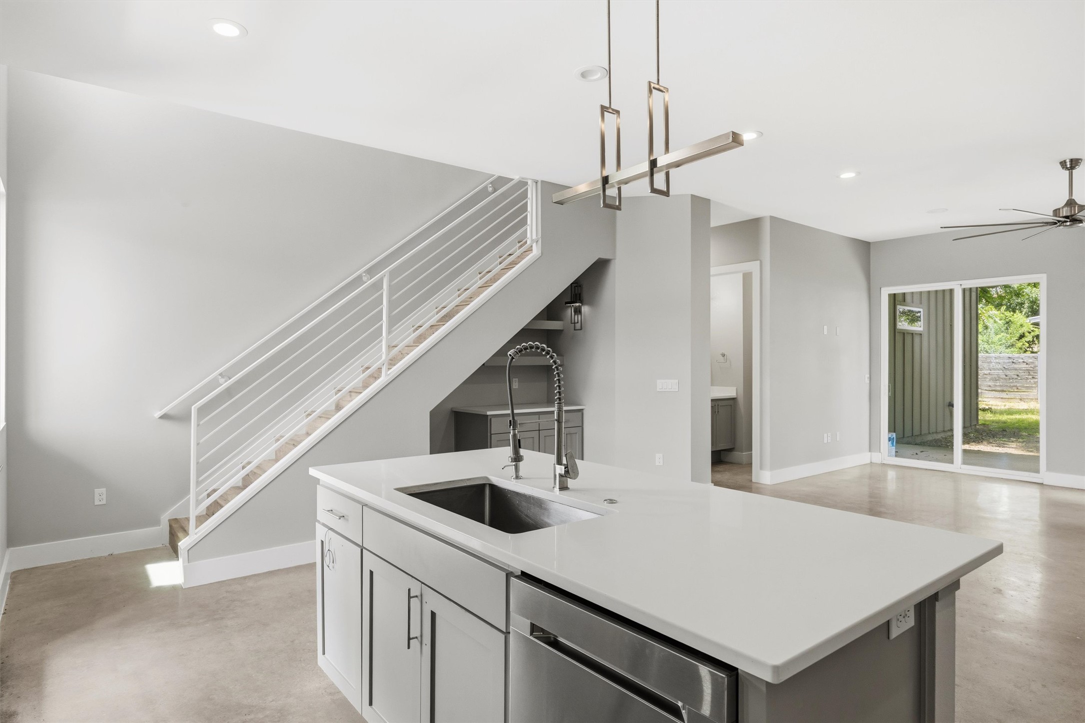 1210 Stobaugh Street, Unit B Austin, TX 78757 - Photo 28 of 40 A sleek island kitchen with white quartz countertops and a modern linear chandelier offers open concept living.