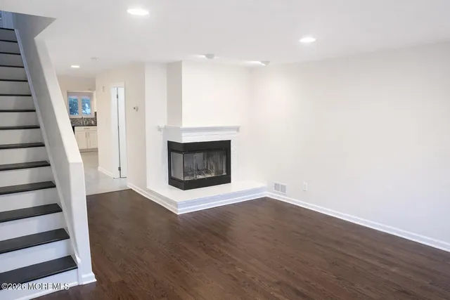 an empty room with wooden floor and a fireplace