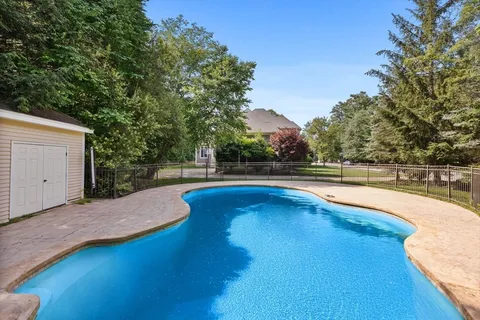 a view of a house with a big yard and large trees