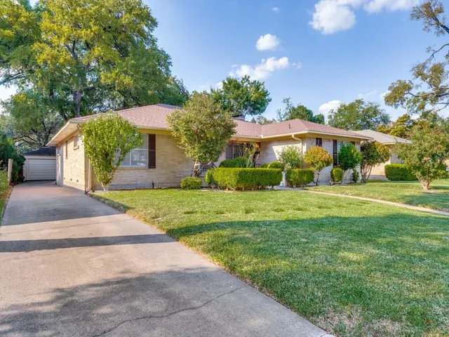 a front view of a house with yard and green space