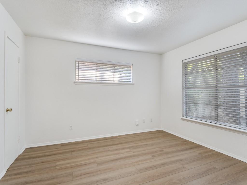 7415-7417 Walling Lane Dallas, TX 75231 - Photo 12 of 25 a view of empty room with wooden floor and fan