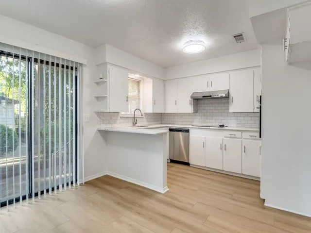 a kitchen with kitchen island granite countertop a sink cabinets and wooden floor