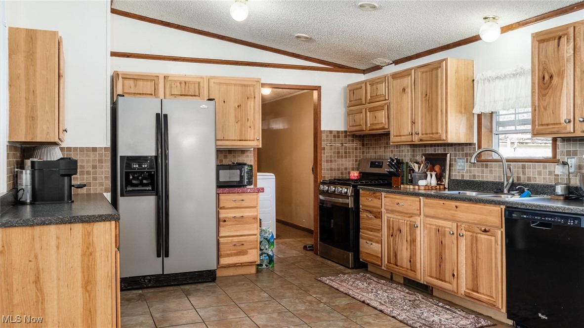 13306 Fairview Road Southeast Newark, OH 43056 - Photo 9 of 48 Kitchen featuring a textured ceiling, black appliances, dark countertops, decorative backsplash, and light tile patterned flooring