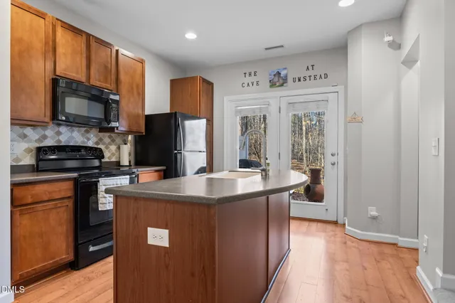 a kitchen with stainless steel appliances granite countertop a refrigerator a stove top oven a sink and dishwasher