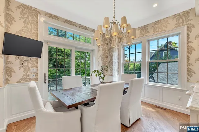 a view of a dining room with furniture large windows and wooden floor