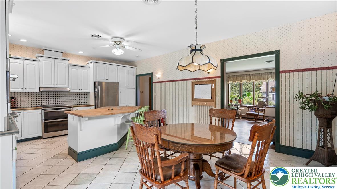 807 Bangor Road Nazareth, PA 18064 - Photo 19 of 46 a kitchen with stainless steel appliances kitchen island granite countertop a dining table chairs and a refrigerator