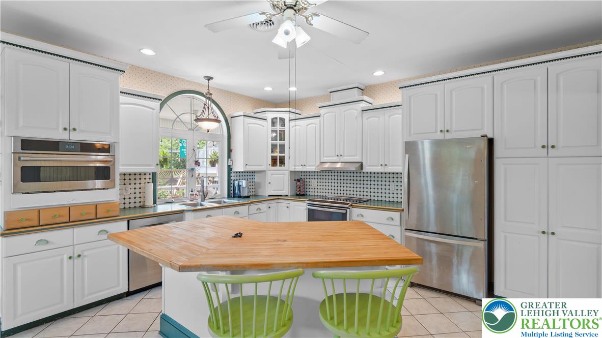 807 Bangor Road Nazareth, PA 18064 - Photo 23 of 46 a kitchen with stainless steel appliances granite countertop a refrigerator a sink dishwasher and white cabinets with wooden floor