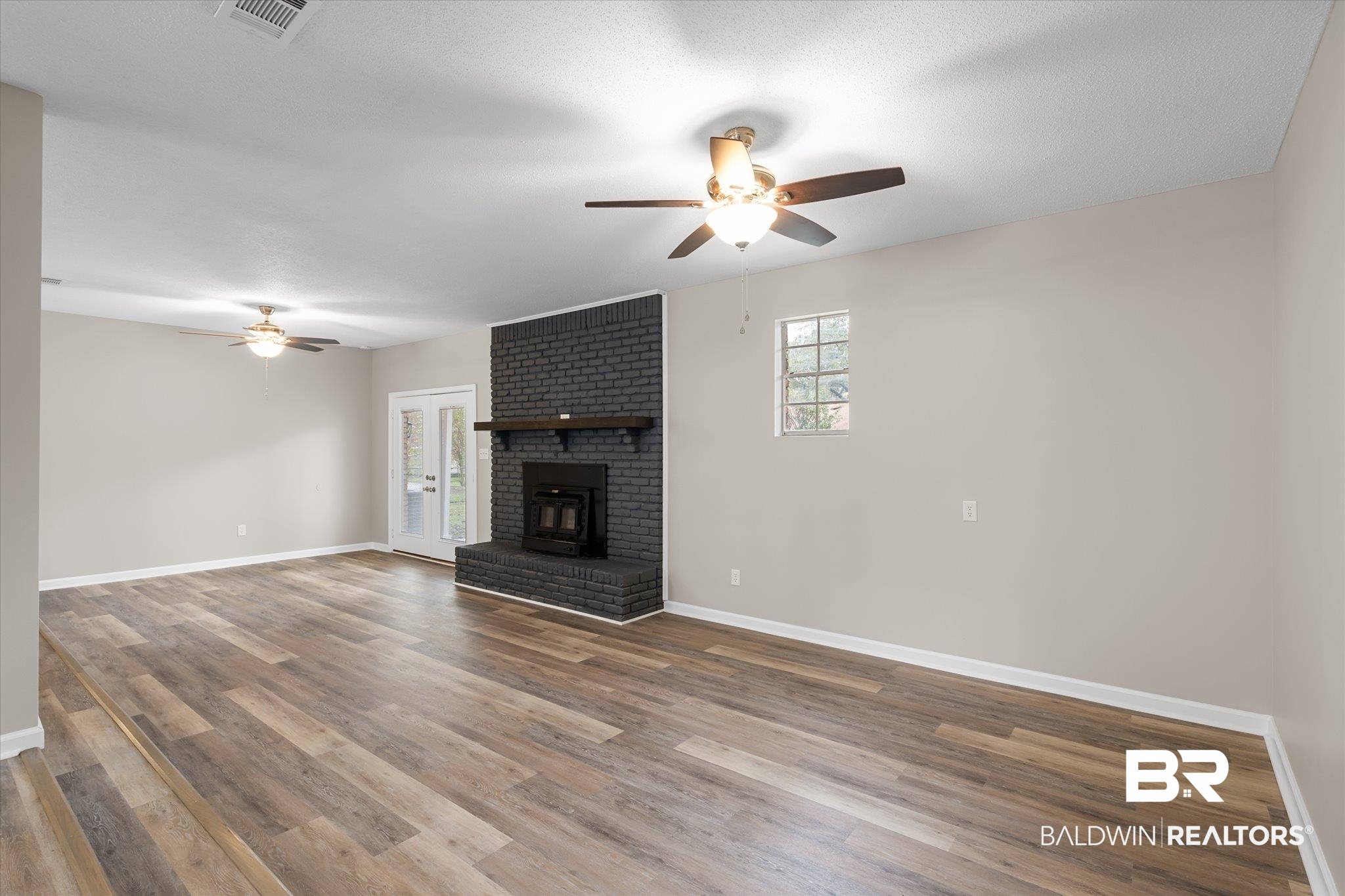 5015 Golfway Drive Eight Mile, AL 36613 - Photo 5 of 31 Unfurnished living room featuring ceiling fan, wood-type flooring, and a textured ceiling