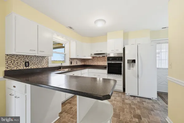 a kitchen with sink cabinets and appliances