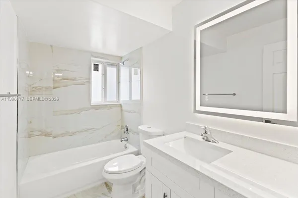 a bathroom with a toilet a sink and bathtub