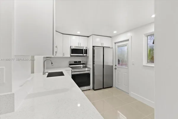 a view of kitchen with kitchen island and stainless steel appliances