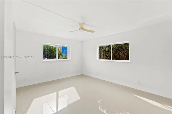 an empty room with windows and closet