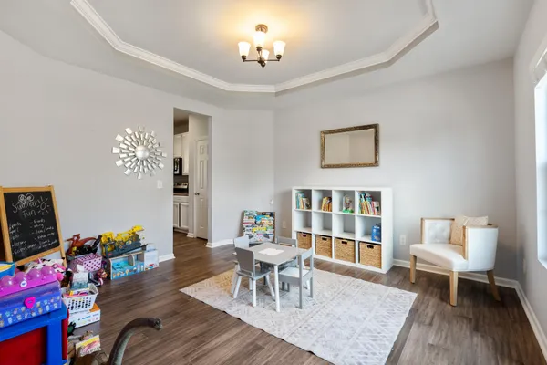 a dining room with wooden floor a chandelier a wooden table and chairs